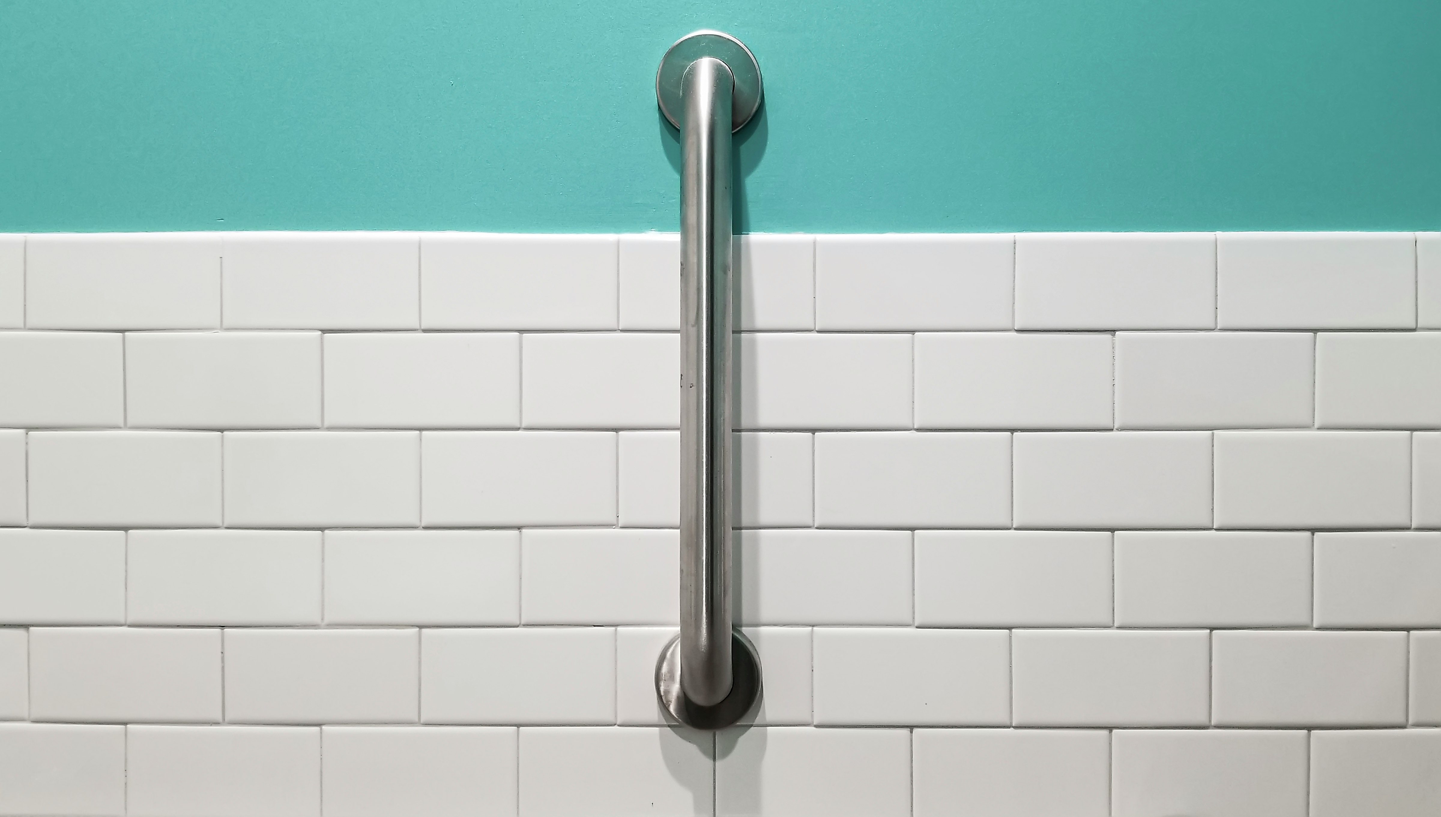 stainless steel shower head on white ceramic wall tiles